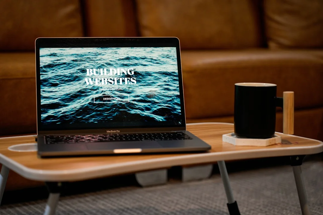 Un espace de travail contemporain avec deux écrans d’ordinateur affichant des projets de web design, soulignant la technologie et la productivité.